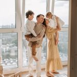 Happy family with children enjoying time together in a sunlit modern apartment.